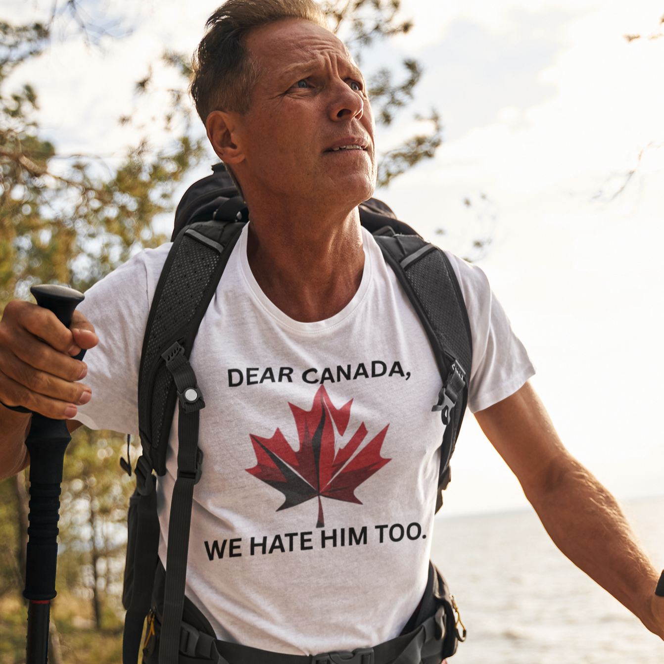 Man hiking in a forest wearing a white t-shirt with a graphic and text.
